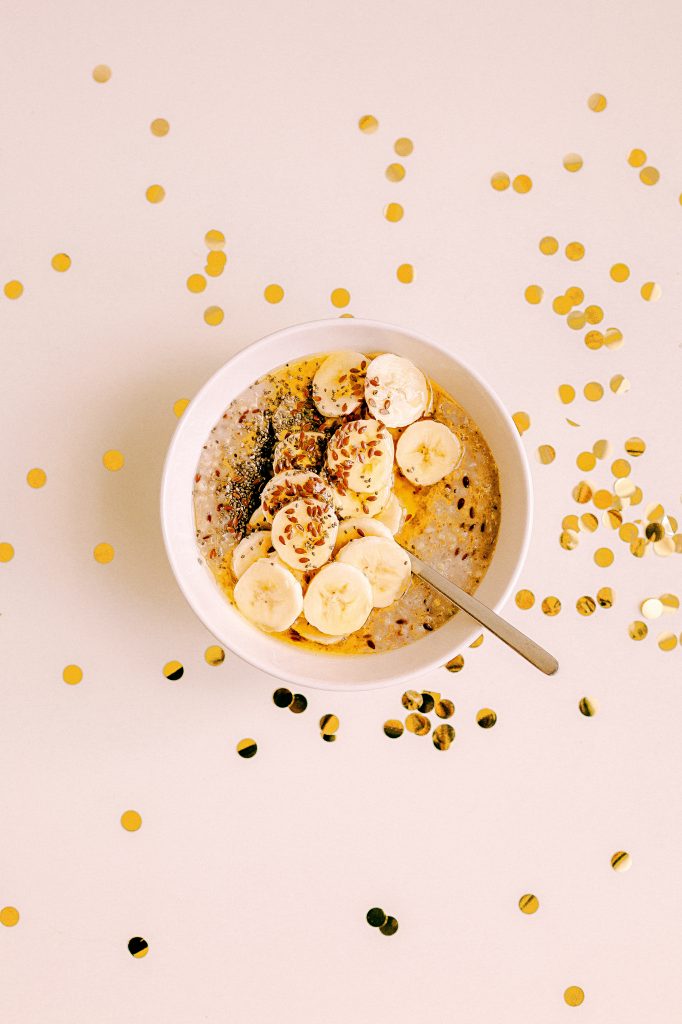 Bowl of bananas and seeds surrounded by large shiny pieces of confetti 